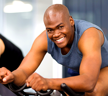 Young African American male works out at The Spine Center on a spin bicycle