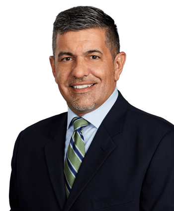 Headshot of Physicians Assistant Joe Ferrao in suit jacket smiling at camera on transparent background